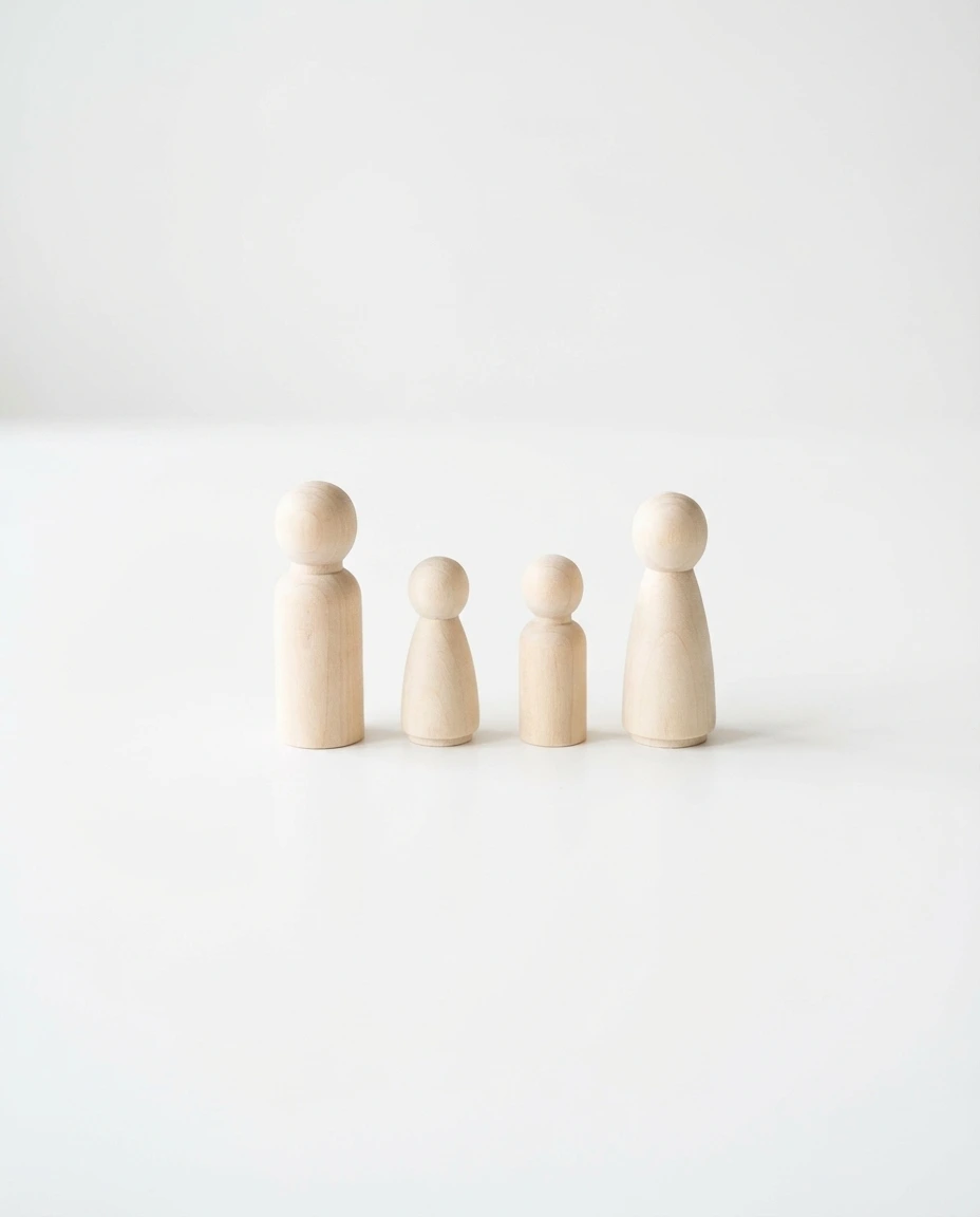 Quattro figure stilizzate in legno che rappresentano una famiglia con due genitori e due figli, simbolo dell'affidamento condiviso e della bigenitorialità
